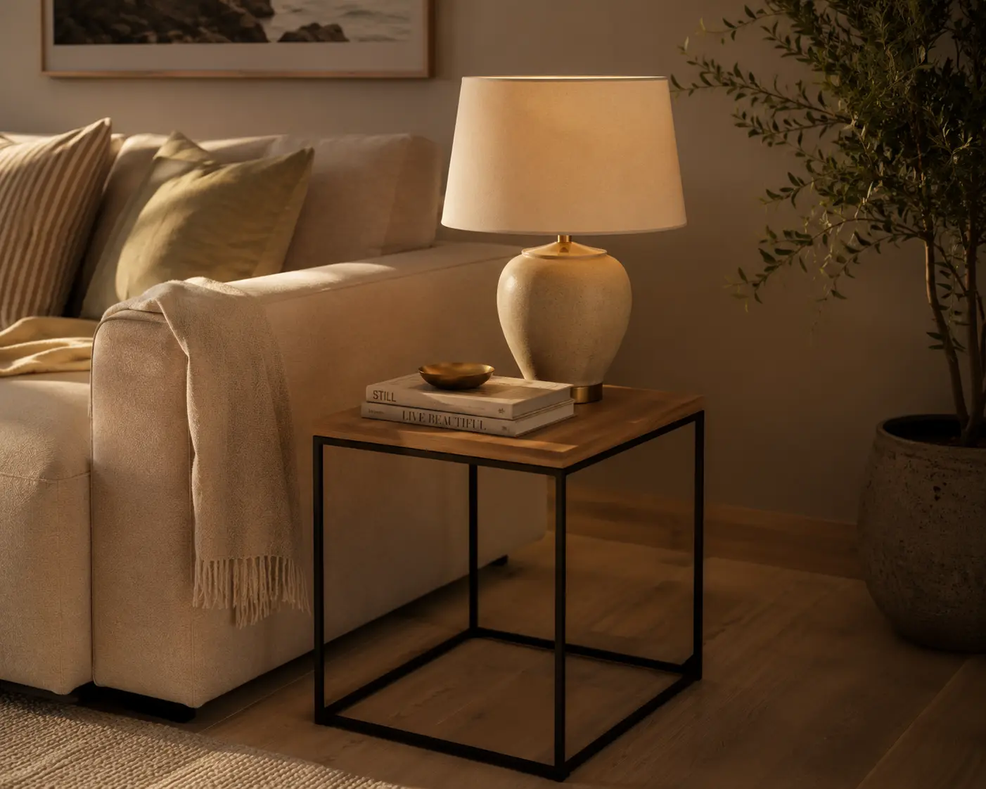 Mixed-material side table with wood top and slim metal frame styled with a lamp and books in a warm neutral living room