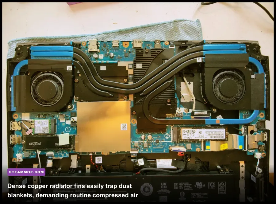 Internal view of opened gaming laptop with dual cooling fans and copper heat pipes being cleaned
