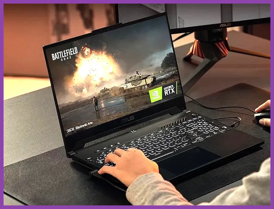 Laptop computer running a PC game on a desk setup