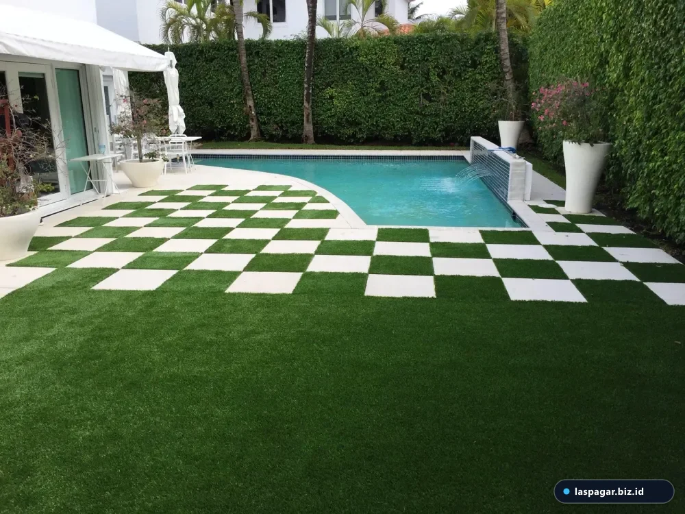 Perpaduan rumput sintetis dan batu koral pada taman rumah subsidi