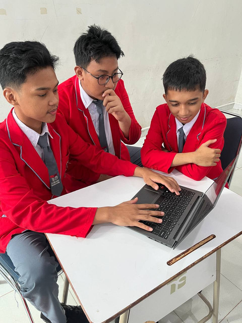 Professional real estate team members discussing documents in a modern office with computers